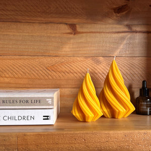 Pointed beeswax candles on shelf
