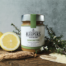 Load image into Gallery viewer, Jar of Immunitea blend with ginseng root and dried astragalus in the foreground, fresh lemon on the left and manuka branch on the right. 
