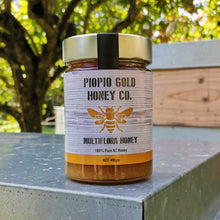 Load image into Gallery viewer, Piopio Gold Honey Co. Multiflora Honey Jar sitting on bee box
